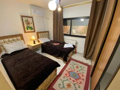 a bedroom with two beds and a window at ROYAL Real ESTATE in Amman