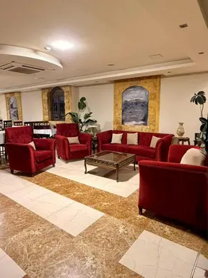 a living room with red couches and a coffee table at Saint John Hotel in Madaba