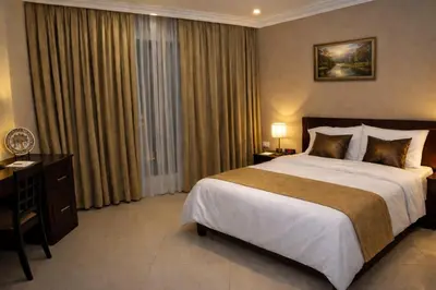 a hotel room with a large bed and a desk at Saint John Hotel in Madaba