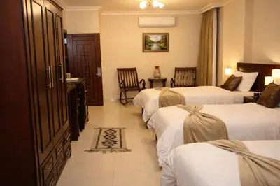 a hotel room with three beds in a room at Saint John Hotel in Madaba