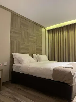 a bedroom with a large bed with a wooden headboard at Mass Paradise Hotel in Aqaba