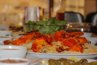 a plate of chicken on rice on a table at Nahas Plaza in Irbid
