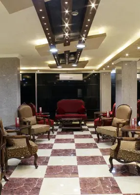 a lobby with red chairs and a checkered floor at Nahas Plaza in Irbid