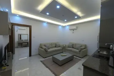 a living room with two couches and a table at Amazing one Bedroom Apartment in Amman Elwebdah 3 in Amman