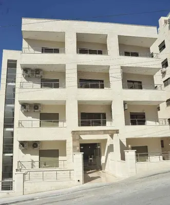 a large white building with a lot of windows at Amazing one Bedroom Apartment in Amman Elwebdah 3 in Amman