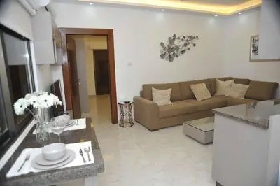 a living room with a couch and a table at Amazing one Bedroom Apartment in Amman Elwebdah 2 in Amman