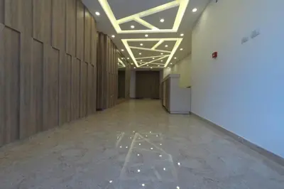 a hallway of an office building with lights on the ceiling at Amazing one Bedroom Apartment in Amman Elwebdah 2 in Amman