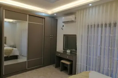 a bedroom with a bed and a tv and a mirror at Amazing one Bedroom Apartment in Amman Elwebdah 2 in Amman
