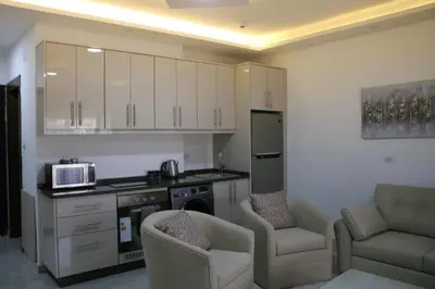 a kitchen with two chairs and a microwave in it at Amazing one Bedroom Apartment in Amman Elwebdah 5 in Amman