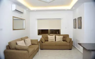 a living room with two chairs and a couch at Amazing one Bedroom Apartment in Amman Elwebdah 6 in Amman