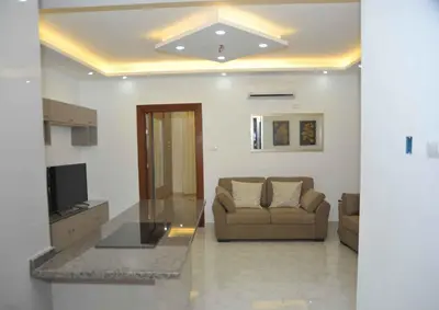 a living room with a couch and a glass table at Amazing one Bedroom Apartment in Amman Elwebdah 6 in Amman