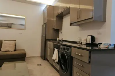a kitchen with a washer and dryer in a room at Amazing one Bedroom Apartment in Amman Elwebdah 1 in Amman