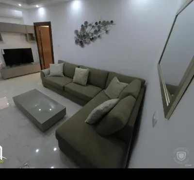 a living room with a couch and a table at Amazing one Bedroom Apartment in Amman Elwebdah 1 in Amman