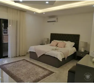 a bedroom with a large bed with pink pillows at Amazing one Bedroom Apartment in Amman Elwebdah 1 in Amman
