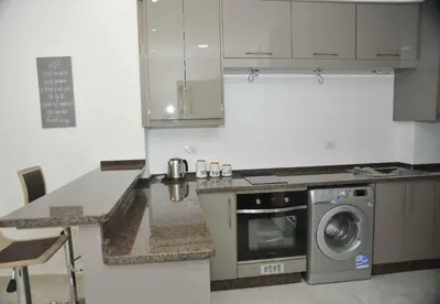 a kitchen with a stove and a washing machine at Amazing one Bedroom Apartment in Amman Elwebdah 4 in Amman