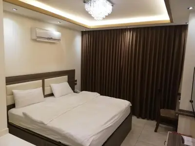 a bedroom with a bed and a chandelier at Seven Days Hotel in Irbid