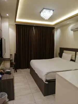 a hotel room with a bed and a chandelier at Seven Days Hotel in Irbid