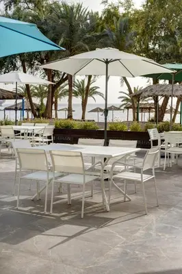 a group of white tables and chairs with umbrellas at Sea view hotel in Aqaba