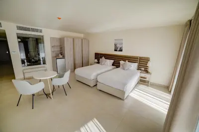 a bedroom with two beds and a table and chairs at Sea view hotel in Aqaba