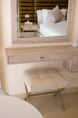 a mirror with a stool in front of a bedroom at Sea view hotel in Aqaba