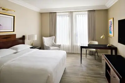a hotel room with a bed and a desk at Sheraton Amman Al Nabil Hotel in Amman