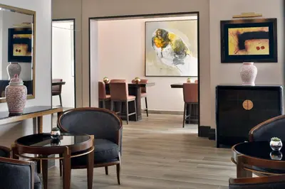 a waiting room with chairs and tables and a painting at Sheraton Amman Al Nabil Hotel in Amman
