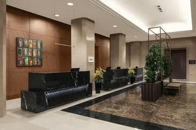 a lobby with a row of chairs and plants at Sheraton Amman Al Nabil Hotel in Amman