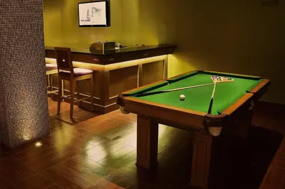 a room with a pool table and a bar at Mosaic City Hotel in Madaba