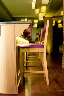 a row of chairs sitting next to a bar at Mosaic City Hotel in Madaba