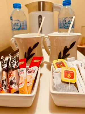 two containers of food and two cups on a table at Mosaic City Hotel in Madaba