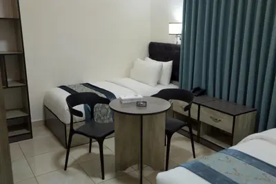 a hotel room with a bed and a table and chairs at Downtown Hotel للعائلات فقط in Aqaba