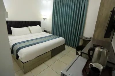 a bedroom with a large bed with green curtains at Downtown Hotel للعائلات فقط in Aqaba