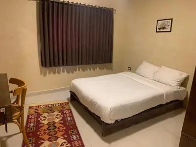 a bedroom with a bed and a window and a rug at Nonna Aisha B&B in Wadi Musa