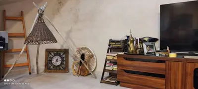 a living room with a tv and a clock and a fan at Nonna Aisha B&B in Wadi Musa