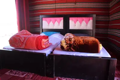 two beds with pillows on them in a room at Luxury Color Camp in Wadi Rum