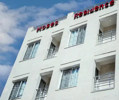 a white building with a sign on top of it at Moses Residence in Wadi Musa