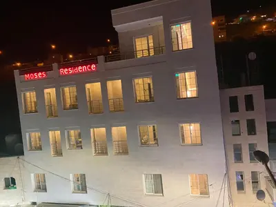 a large white building with lit windows at night at Moses Residence in Wadi Musa