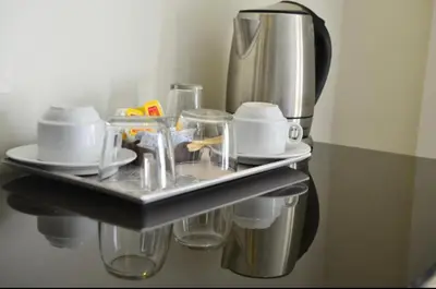 a shelf with cups and plates and a coffee pot at Moses Residence in Wadi Musa