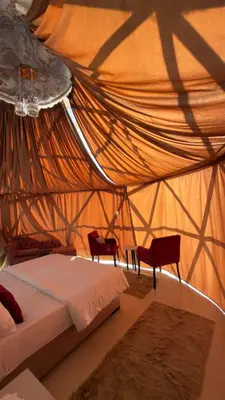 a bedroom with a bed and two chairs and a net at Luxury Desert & Bedouin Adventure in Wadi Rum