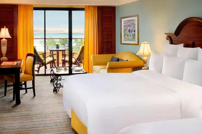 a hotel room with a large bed and a balcony at Dead Sea Marriott Resort & Spa in Sowayma