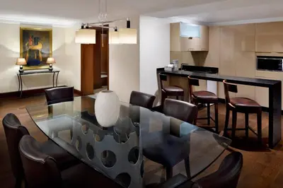a dining room with a glass table and chairs at Dead Sea Marriott Resort & Spa in Sowayma