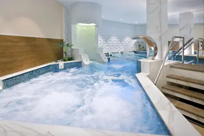 a jacuzzi tub in a hotel with blue water at Amman Marriott Hotel in Amman
