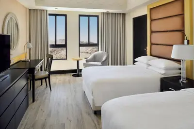 a hotel room with two beds and a desk at Petra Marriott Hotel in Wadi Musa