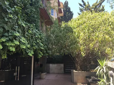 a courtyard with trees and a building with a gate at Shepherd Hotel in Amman