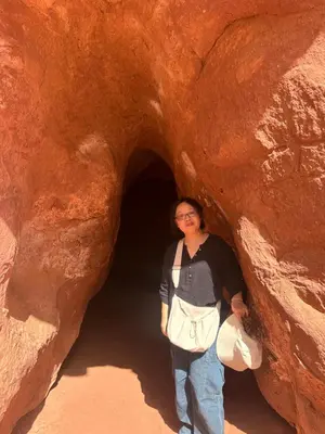 a woman standing in front of a rock tunnel at Bubbles Desert Camp Jeep Tours in Wadi Rum