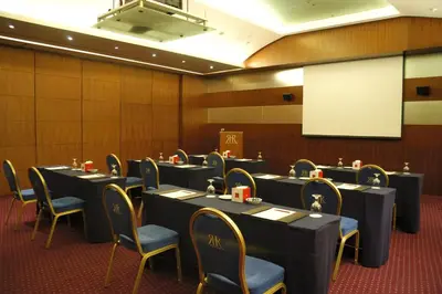 a conference room with tables and chairs and a whiteboard at Le Royal Hotel - Amman in Amman