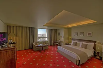 a hotel room with a large bed and a television at Le Royal Hotel - Amman in Amman