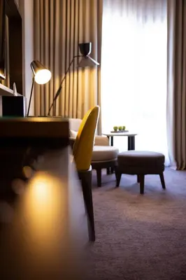 a living room with a couch and a chair and a lamp at Centro Mada Amman by Rotana in Amman