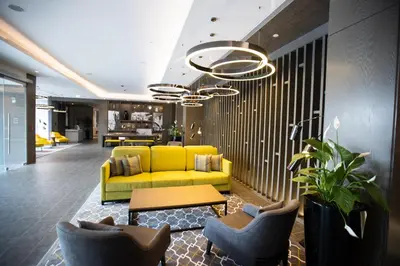 a living room with a yellow couch and a table at Centro Mada Amman by Rotana in Amman