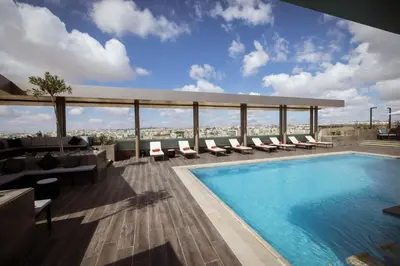 a pool on the roof of a building at Centro Mada Amman by Rotana in Amman